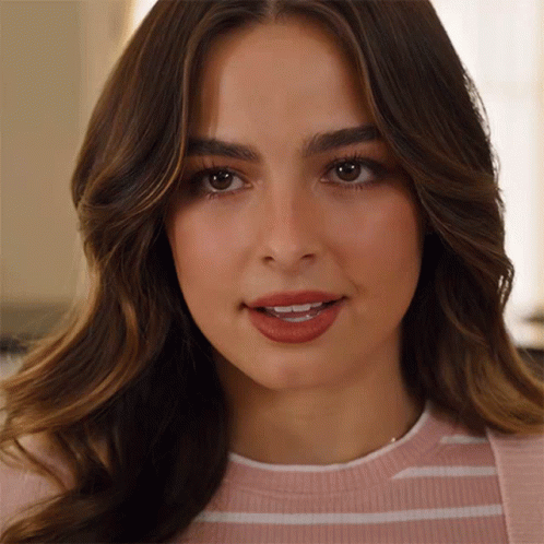 A Close Up Of A Woman 'S Face With A Pink And White Striped Shirt On GIF