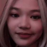 A Close Up Of A Woman 'S Face With A Pink Background And A Blurred Background . GIF