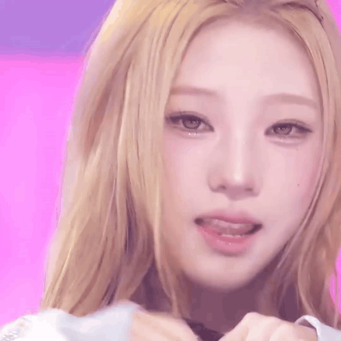 A Close Up Of A Woman 'S Face With A Pink Background . GIF