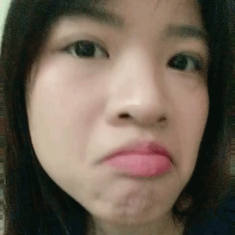 A Close Up Of A Woman 'S Face With A Pink Lip . GIF