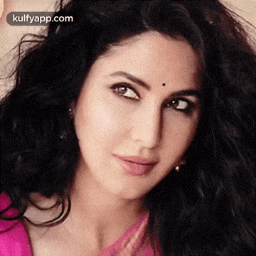 A Close Up Of A Woman 'S Face With A Pink Top And Black Hair . GIF