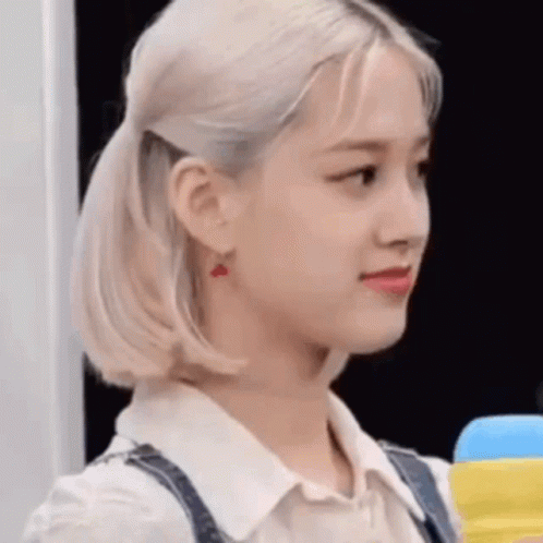 A Close Up Of A Woman 'S Face With A Ponytail And Earrings . GIF