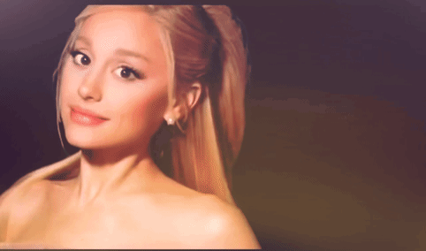 A Close Up Of A Woman 'S Face With A Ponytail And Earrings GIF