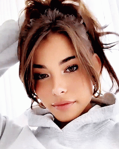A Close Up Of A Woman 'S Face With A Ponytail GIF