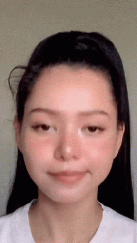 A Close Up Of A Woman 'S Face With A Ponytail . GIF
