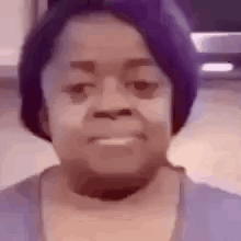 A Close Up Of A Woman 'S Face With A Purple Hat . GIF