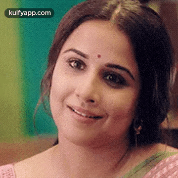 A Close Up Of A Woman 'S Face With A Red Dot On Her Forehead And Smiling . GIF