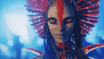 A Close Up Of A Woman 'S Face With A Red Feathered Headpiece GIF