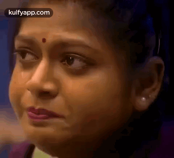 A Close Up Of A Woman 'S Face With A Red Spot On Her Nose . GIF