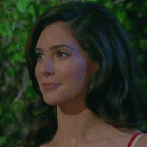 A Close Up Of A Woman 'S Face With A Red Top On GIF