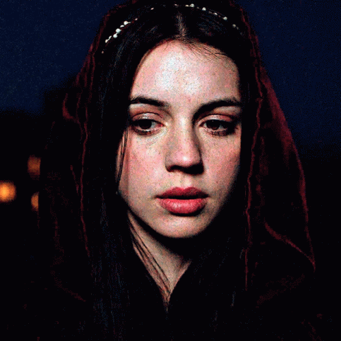 A Close Up Of A Woman 'S Face With A Red Veil Covering Her Head GIF