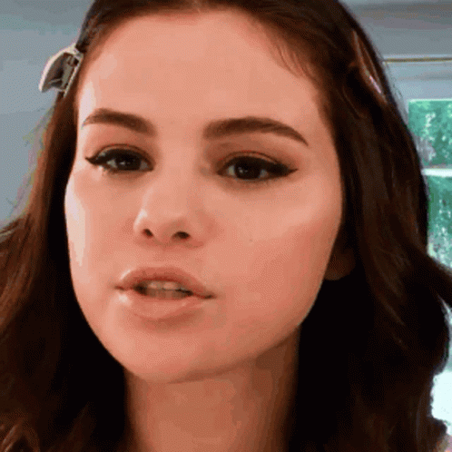 A Close Up Of A Woman 'S Face With A Ribbon In Her Hair GIF