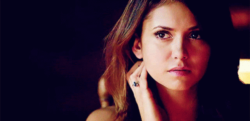 A Close Up Of A Woman 'S Face With A Ring On Her Finger . GIF