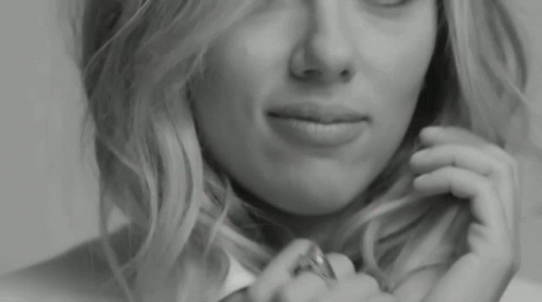 A Close Up Of A Woman 'S Face With A Ring On Her Finger . GIF
