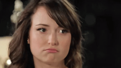 A Close Up Of A Woman 'S Face With A Sad Look On Her Face GIF