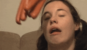 A Close Up Of A Woman 'S Face With A Sausage On Her Head . GIF