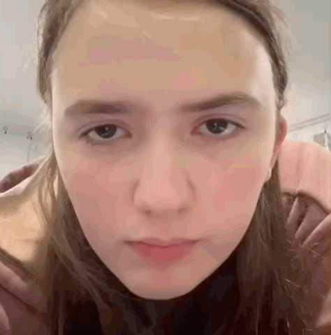 A Close Up Of A Woman 'S Face With A Serious Look On Her Face GIF