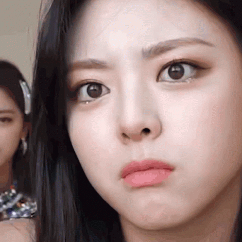 A Close Up Of A Woman 'S Face With A Serious Look On Her Face . GIF
