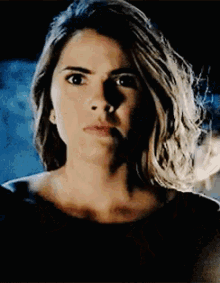 A Close Up Of A Woman 'S Face With A Shadow On Her Face And A Black Background . GIF