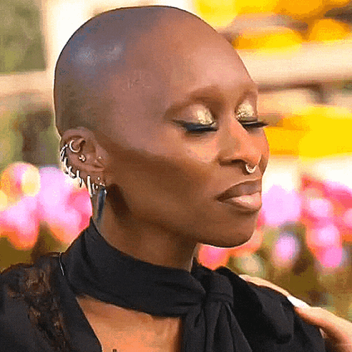 A Close Up Of A Woman 'S Face With A Shaved Head And Nose Ring GIF