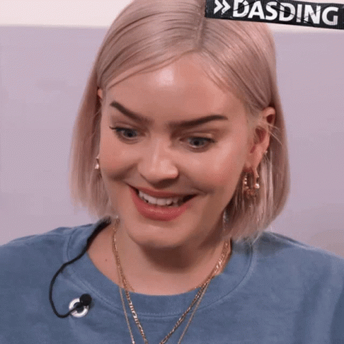 A Close Up Of A Woman 'S Face With A Sign That Says Dasding Behind Her GIF