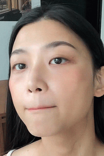 A Close Up Of A Woman 'S Face With A Slight Smile GIF