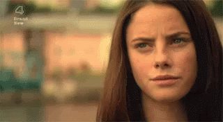 A Close Up Of A Woman 'S Face With A Slight Smile On Her Face . GIF