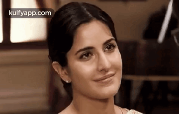 A Close Up Of A Woman 'S Face With A Slight Smile On Her Face . GIF