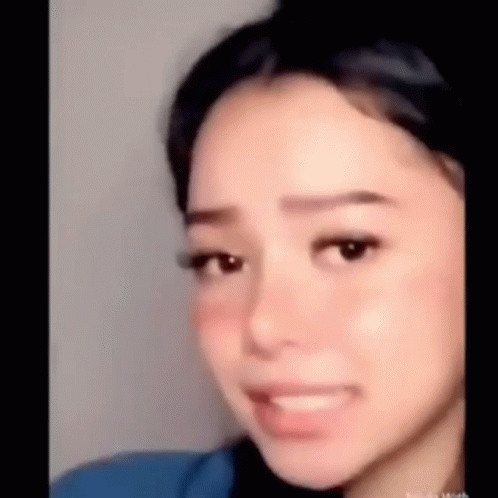 A Close Up Of A Woman 'S Face With A Slight Smile On Her Face . GIF