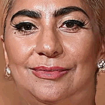 A Close Up Of A Woman 'S Face With A Slight Smile On It . GIF
