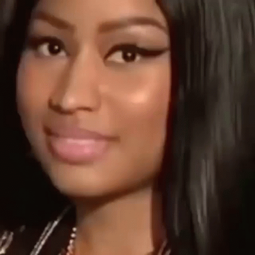 A Close Up Of A Woman 'S Face With A Smile On Her Face And A Necklace . GIF