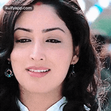 A Close Up Of A Woman 'S Face With A Smile On Her Face And Earrings . GIF