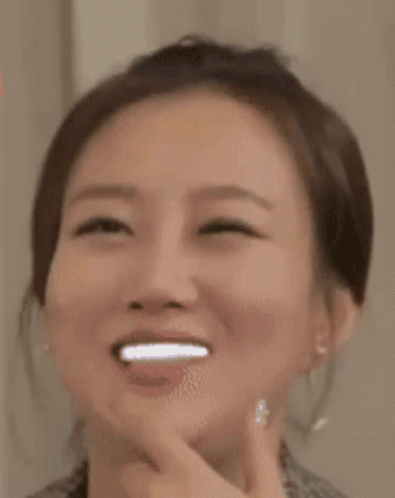 A Close Up Of A Woman 'S Face With A Smile On Her Face . GIF