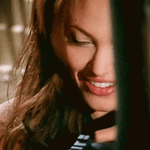 A Close Up Of A Woman 'S Face With A Smile On Her Face . GIF