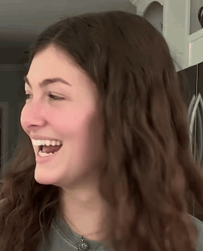A Close Up Of A Woman 'S Face With A Smile On Her Face GIF