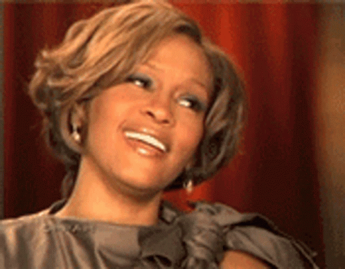 A Close Up Of A Woman 'S Face With A Smile On Her Face . GIF