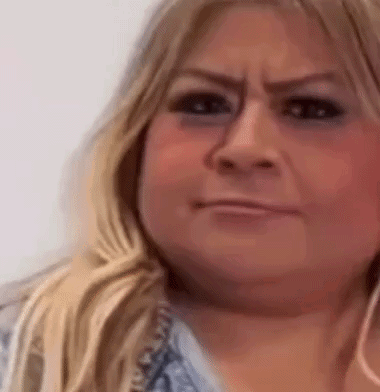 A Close Up Of A Woman 'S Face With A Smirk On Her Face . GIF