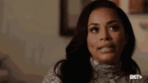 A Close Up Of A Woman 'S Face With A Snake Print Sweater On . GIF
