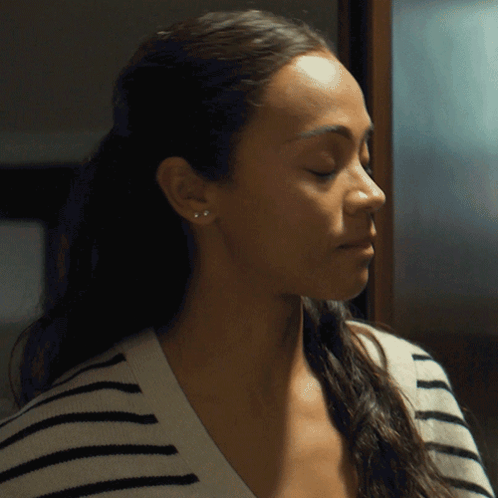 A Close Up Of A Woman 'S Face With A Striped Shirt GIF