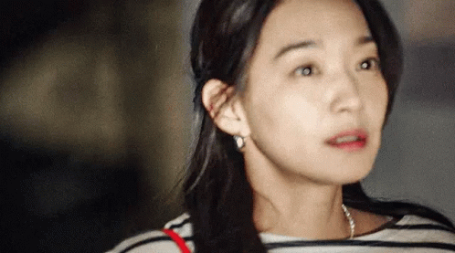 A Close Up Of A Woman 'S Face With A Striped Shirt On . GIF