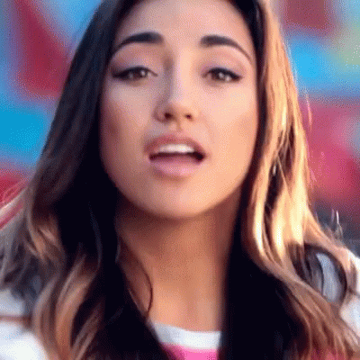 A Close Up Of A Woman 'S Face With A Striped Shirt On GIF