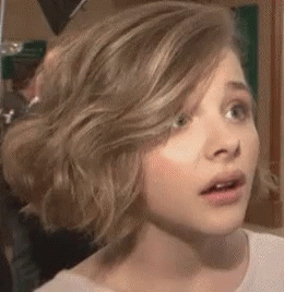 A Close Up Of A Woman 'S Face With A Surprised Expression On Her Face . GIF
