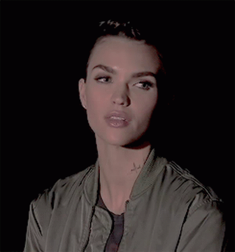 A Close Up Of A Woman 'S Face With A Tattoo On Her Neck GIF
