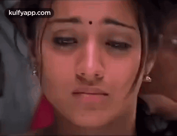 A Close Up Of A Woman 'S Face With A Tear Coming Out Of Her Eye . GIF