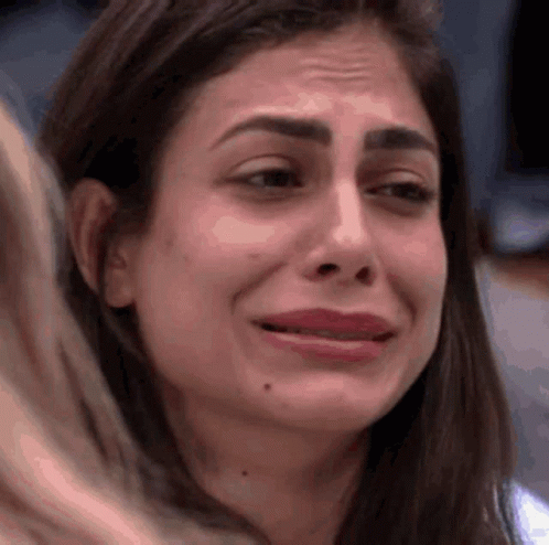 a close up of a woman 's face with a tear running down her cheek .