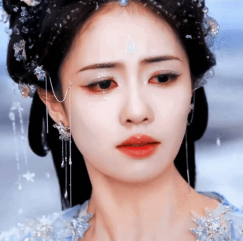A Close Up Of A Woman 'S Face With A Tear Running Down Her Cheek GIF