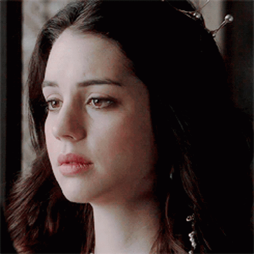 A Close Up Of A Woman 'S Face With A Tiara On Her Head . GIF