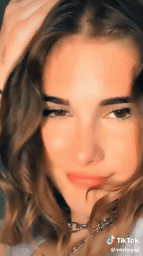A Close Up Of A Woman 'S Face With A Tiktok Logo In The Corner GIF