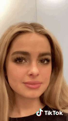 A Close Up Of A Woman 'S Face With A Tiktok Logo On The Bottom Right GIF