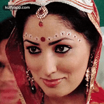 A Close Up Of A Woman 'S Face With A Veil On Her Head And A Bindi On Her Forehead . GIF